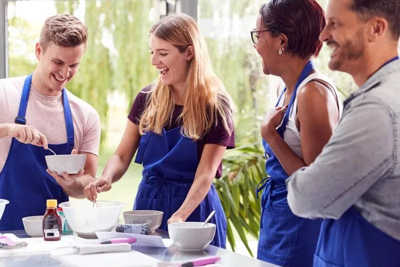 Colleagues laughing together during a group cooking class