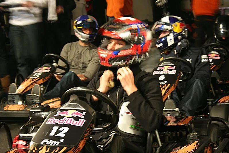 Team members in helmets ready for an indoor karting race