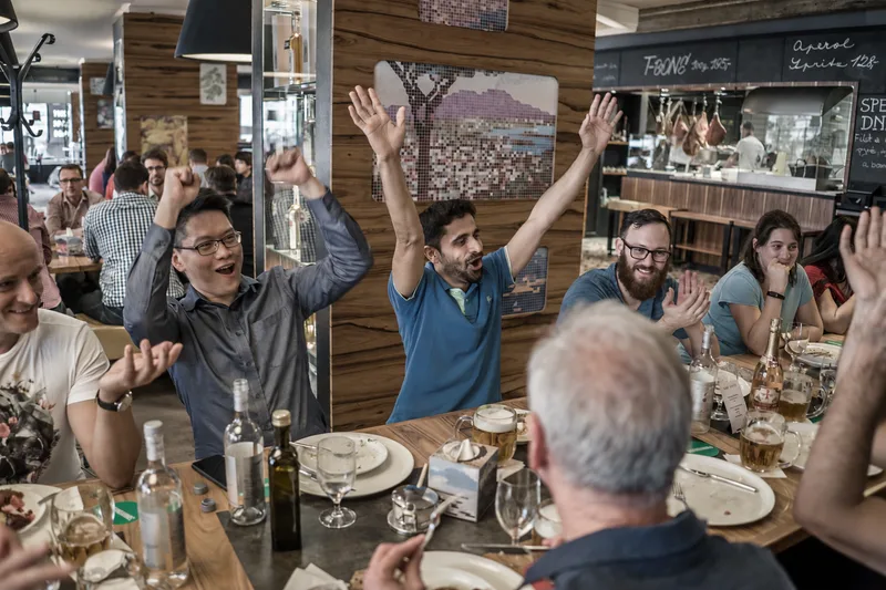Teams cheering at the award ceremony over lunch in a restaurant