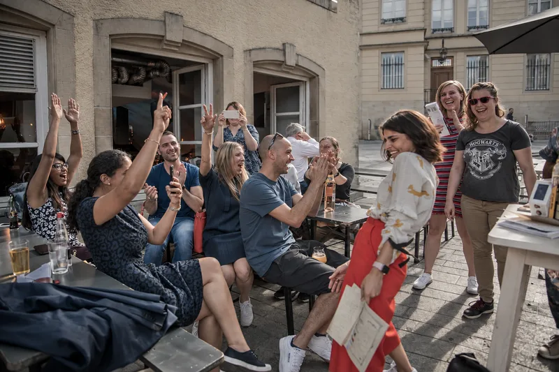 Teams cheering at an outdoor terrace as the Game Master announces the results