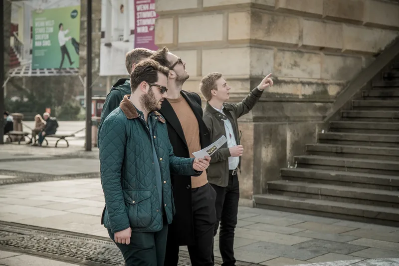 Treasure hunt team with a clue sheet pointing out the next stop on Gendarmenmarkt in Berlin