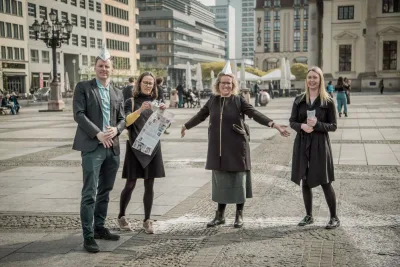 Team members holding their treasure hunt booklets on a Berlin square