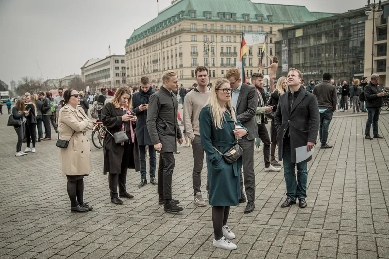 Large corporate group gathering on Pariser Platz for the treasure hunt briefing