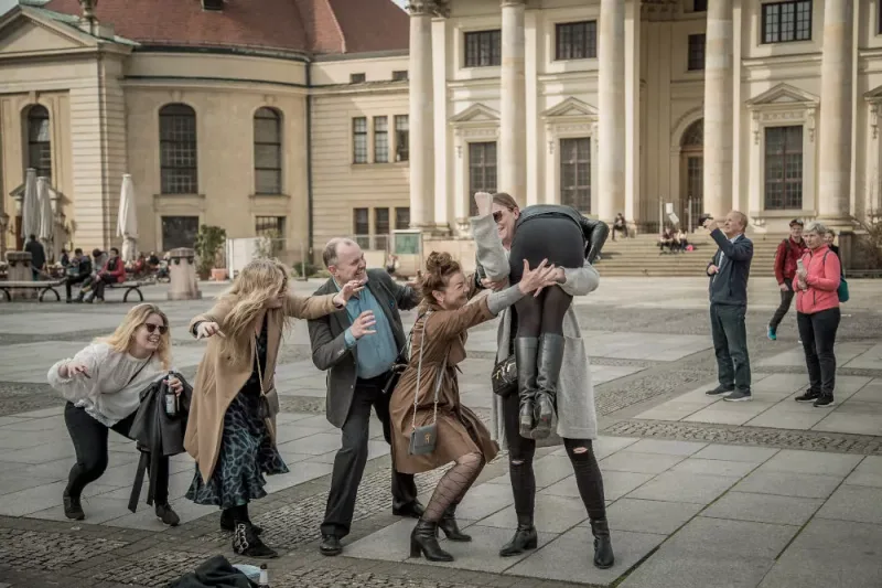 Colleagues acting out a photo challenge on a Berlin square