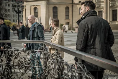 Treasure hunt players by an ornate iron railing, looking for the next clue