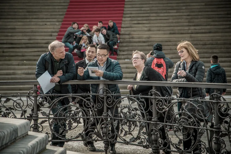 Treasure hunt teams working on their clues at the railing on Gendarmenmarkt