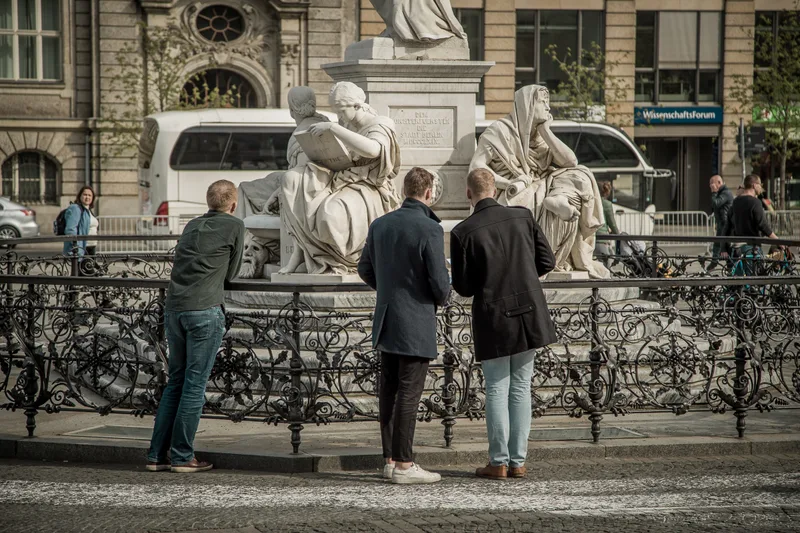 Treasure hunt team studying the Schiller Monument on Gendarmenmarkt in Berlin