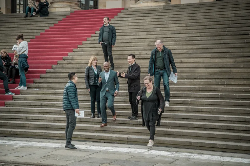 Several treasure hunt teams working on the steps of the Konzerthaus on Gendarmenmarkt