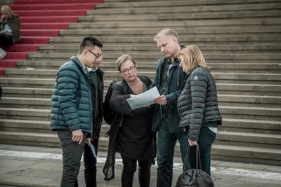 A treasure hunt team studying a clue together on historic steps in Berlin-Mitte