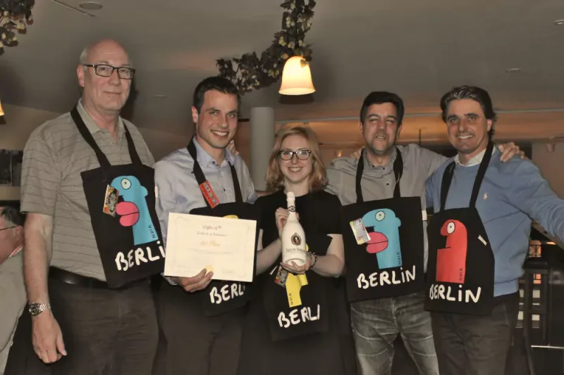 Winning team celebrating with their diploma at a Berlin restaurant