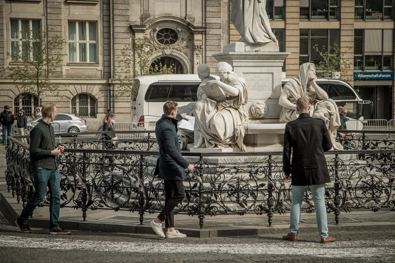 Players with a map searching for answers at the Schiller Monument on Gendarmenmarkt